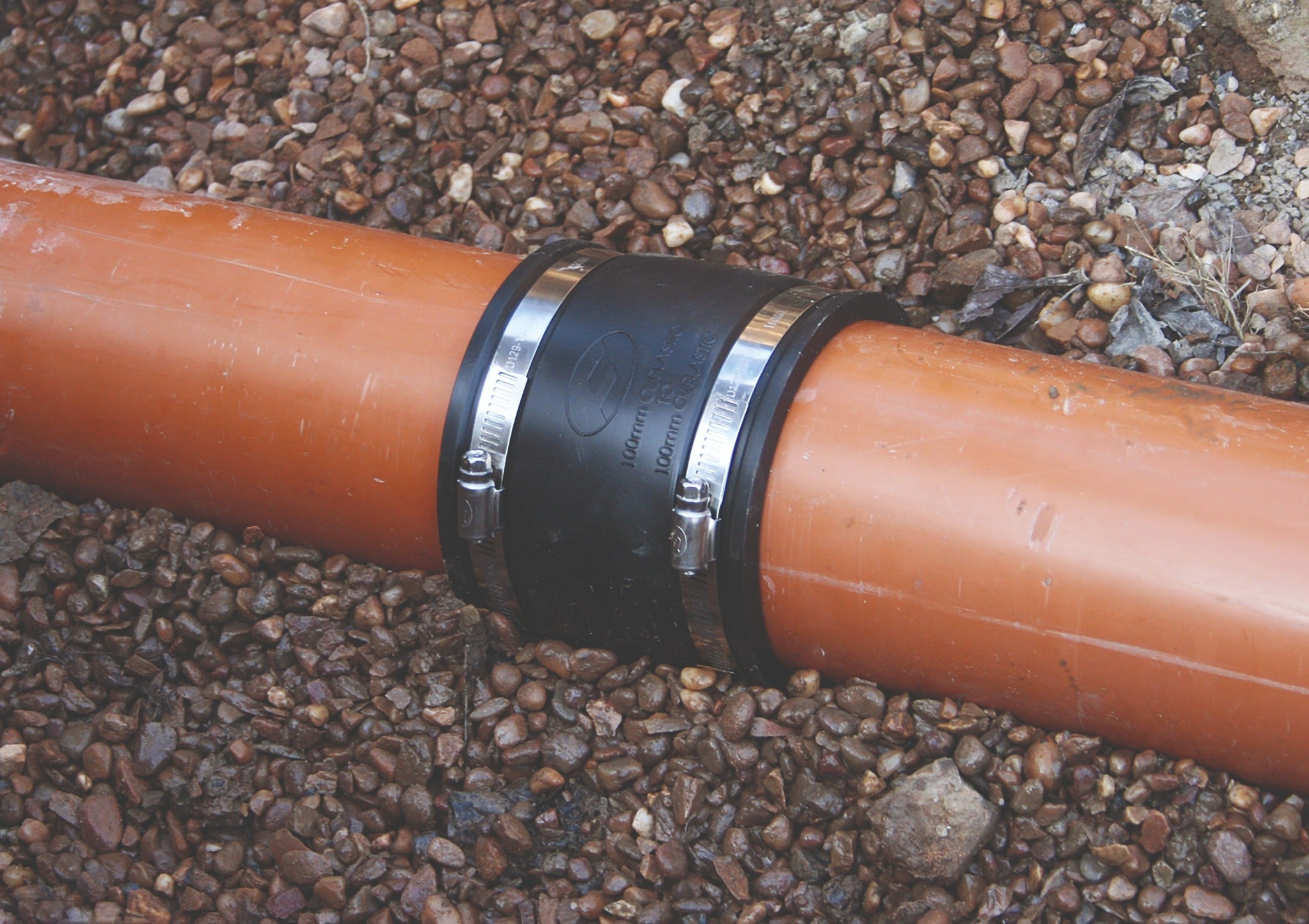 Fernco EPDM straight plumbing coupling installed on drainage pipe