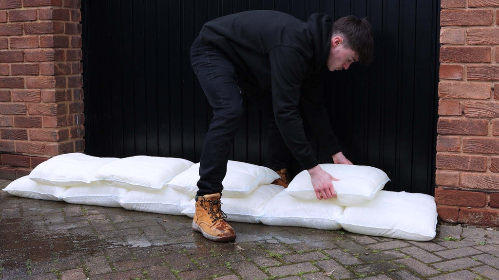 Fernco Floodbags being placed to form a flood barrier